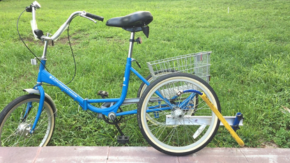 a blue adult trike from the side showing a yellow Bike Tow Leash® attached to a Trike Adaptor® on the Trike